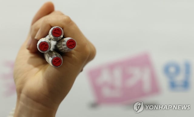 An election worker holds voting stamps at an early voting station in Seoul's southwestern ward of Gwanak on May 28, 2025. (Yonhap)