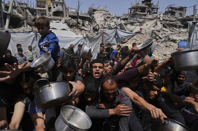 Palestinos luchan por conseguir alimentos donados en una cocina comunitaria de Beit Lahia, en el norte de la Franja de Gaza.