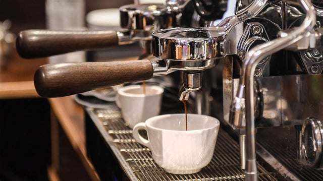 Kaffee läuft aus einer Siebträger-Kaffeemaschine in eine Tasse.