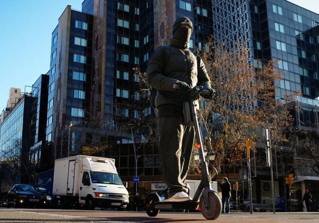 Un hombre circula por el centro de Barcelona con un patinete eléctrico