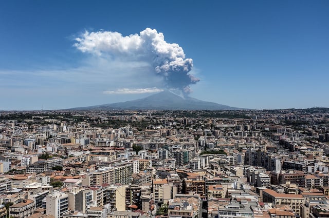 CATANIA, ITALY - JUNE 02: Mount Etna exhibits a Strombolian eruption, with a volcanic plume rising from the southeast crater, on June 02, 2025 in Catania, Italy. An orange aviation warning has been issued. The images show aerial views of the volcano with the city of Catania in the background. (Photo by Fabrizio Villa/Getty Images)