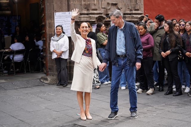 Mexico's President Claudia Sheinbaum waves, as she stands with her husband Jesus Maria Tarriba, after voting at a polling station to vote during the judicial and magistrate election, in Mexico City, Mexico June 1, 2025. REUTERS/Toya Sarno Jordan