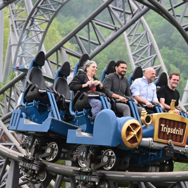 Die 85 -jährige Ursel Dees (l) fährt mit der Achterbahn Karacho einen Looping. Mit im Wagen sitzen Benjamin Fischer (vl), Mitglied der Geschäftsführung Tripsdrill, Stefan Seipel, Geschäftsführer Tripsdrill, und Markus Dees , der Enkel.