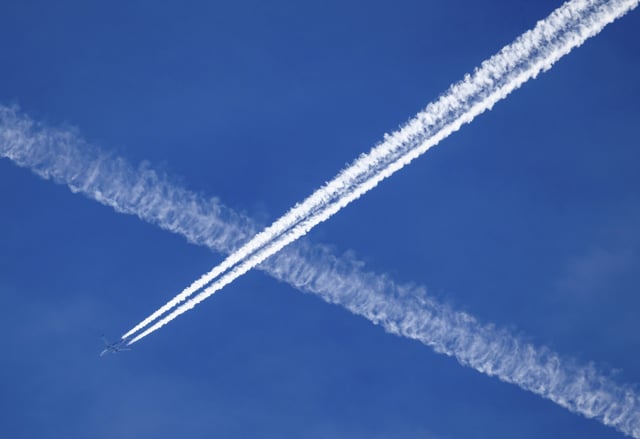 19 March 2024, Saxony, Dresden: An airplane leaves contrails in the blue sky.