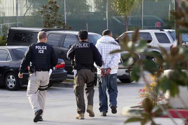 Immigration and Customs Enforcement (ICE) agents take a suspect into custody in Chula Vista, Califronia.