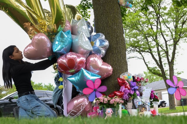Kimberly Ponce, 11, straightens a poster in the memorial for Eyani Jones, 10, and sister, Janiya Jenkins, 21, near the family’s Streamwood town home, May 30, 2025. Ponce was a friend of Eyani Jones and said &#34;She was very nice and always complimented me on my outfits. She was a really good friend. Every time I saw her, she made my day.&#34; (Stacey Wescott/Chicago Tribune)