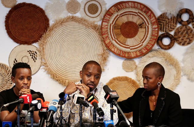 Kenyan activist Boniface Mwangi is comforted by his wife, Njeri Mwangi, as he addresses a press conference together with Ugandan activist Agather Atuhaire, with whom he was detained upon arrival in Dar es Salaam to attend the first court appearance of Tanzanian opposition leader Tundu Lissu, and later released, in Nairobi, Kenya June 2, 2025. REUTERS/Thomas Mukoya