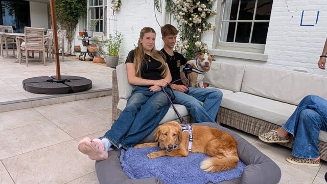 Amber, lying in the bed, with her foster family after being brought back home