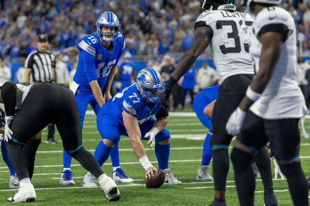 Nov 17, 2024; Detroit, Michigan, USA; Detroit Lions quarterback Jared Goff (16) lines up for the snap behind center Frank Ragnow (77) during the first half of the game against the Jacksonville Jaguars at Ford Field. Mandatory Credit: David Reginek-Imagn Images