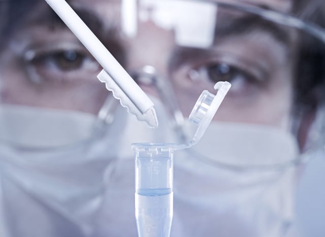 A police employee tests Polymerase Chain Reaction (PCR) on a saliva sample for criminal analysis.