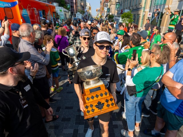 Denver Barkey carries the Memorial Cup behind Easton Cowan, holding the trophy he won as tournament MVP, as the London Knights celebrated with fans along Dundas Place in downtown London roughly 24 hours after winning the national junior hockey championship. Photo taken on June 2, 2025. (Mike Hensen/The London Free Press)