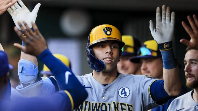 Jun 2, 2025; Cincinnati, Ohio, USA; Milwaukee Brewers designated hitter Christian Yelich (22) high fives teammates after hitting a solo home run in the third inning against the Cincinnati Reds at Great American Ball Park. Mandatory Credit: Katie Stratman-Imagn Images