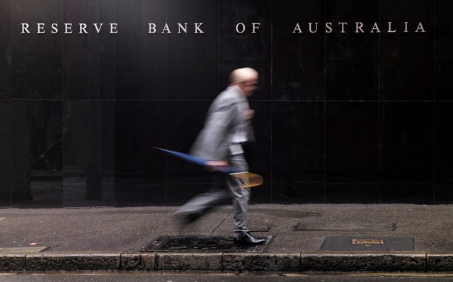 A businessman walks past the headquarters of Australia's Reserve Bank in Sydney, November 3, 2015.  REUTERS/Jason Reed/File Photo
