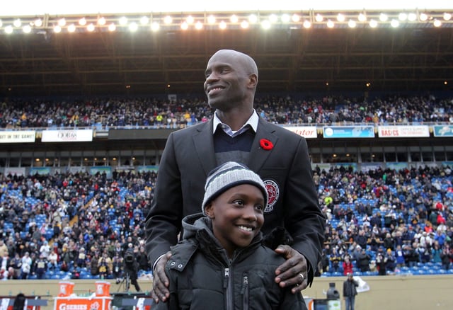 Milt Stegall with his son, Chase, during a ceremony for the hall of fame inductees at half-time in CFL action between the Winnipeg Blue Bombers and the Montreal Alouettes in Winnipeg Saturday, November 3, 2012. (CFL PHOTO - Marianne Helm)