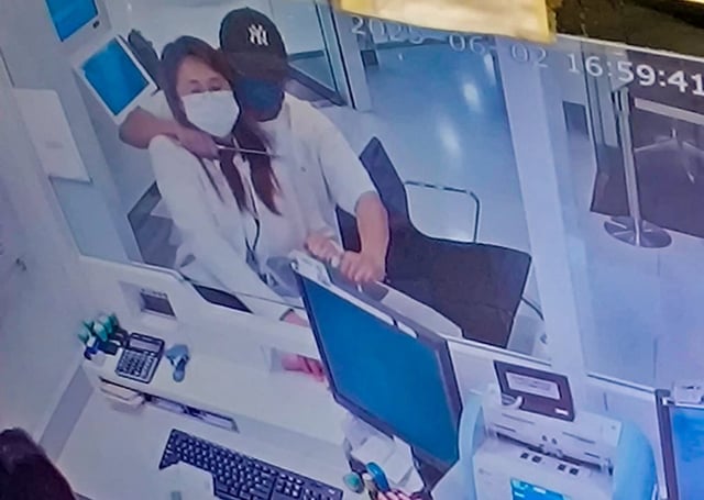 A screen grab of CCTV footage circulating online shows the robber holding a knife at the bank worker’s throat. Photo: Handout