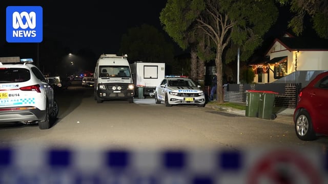 police cars outside a house in croydon park where a man was stabbed and another arrested