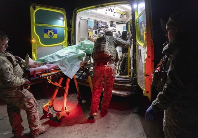 Soldados ucranianos trasladan a un compañero herido para que reciba atención médica.