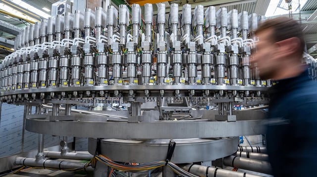 Ein Mitarbeiter geht an einer Abfüllanlage in der Produktion eines Maschinenbauunternehmens vorbei.