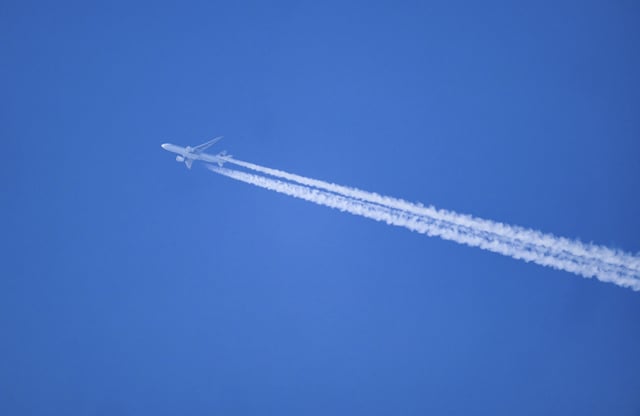 06 March 2024, Saxony, Dresden: An airplane leaves contrails in the blue sky.