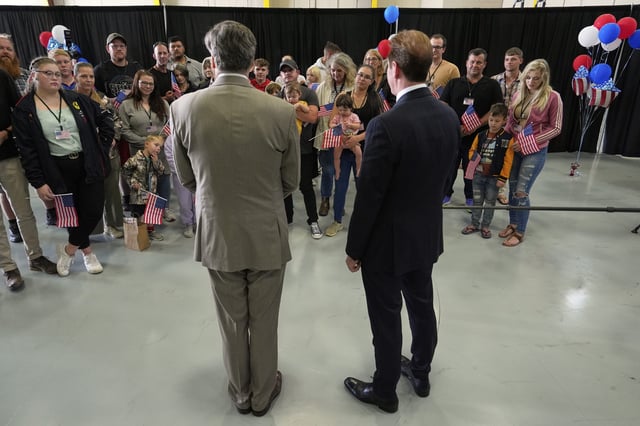 Deputy Secretary of State Christopher Landau, left, greets the first group of Afrikaner refugees from South Africa, Monday, May 12, 2025, at Dulles International Airport in Dulles, Va.