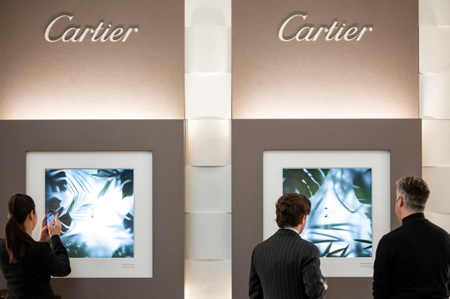 Visitors look at watch models at the Cartier booth at the Watches and Wonders exhibition in Geneva, Switzerland, April 9, 2024. REUTERS/Pierre Albouy/File Photo