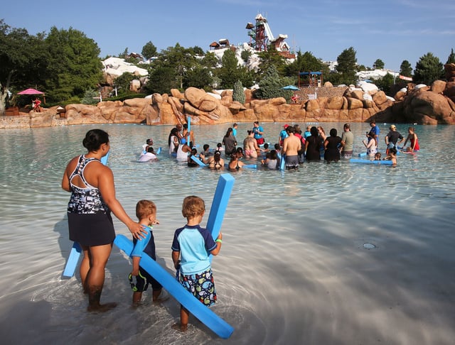 Roberta Nuckols walks with her sons, Ian, 3, and Evan, 4, to join children of Walt Disney World cast members and from the Boys &amp; Girls Clubs of Central Florida in “The World’s Largest Swimming Lesson,” at Disney’s Blizzard Beach Water Park in Lake Buena Vista, Florida, on Thursday, June 20, 2019. 