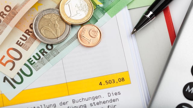 Geldscheine, Münzen und Kontoauszug
