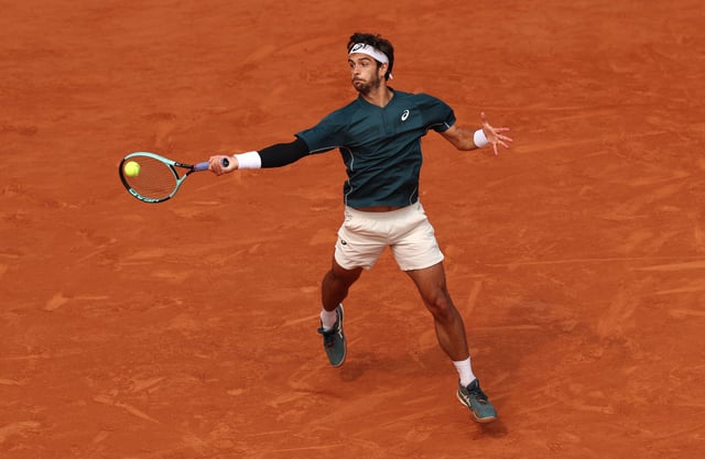 Musetti plays a forehand against Tiafoe.