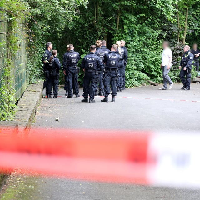 Solingen: Einsatzkräfte der Polizei stehen hinter einem Absperrband auf einem Grundstück