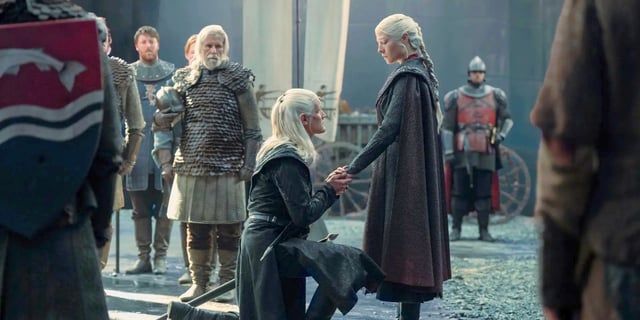 Daemon Targaryen (Matt Smith) kneeling in front of Rhaenyra Targaryen (Emma D'Arcy) and holding her hand in both of his in the House of the Dragon Season 2 finale.