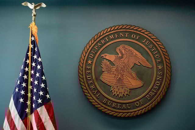 An American flag and the seal for the Federal Bureau of Prisons at the Federal Bureau of Prisons headquarters in Washington, D.C., on Oct. 24, 2022.