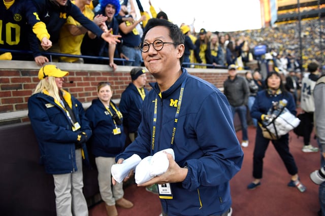 Then-University of Michigan President Santa Ono prepares to toss t-shirts into the crowd during the second half of an NCAA college football game against Oregon, in Ann Arbor, Mich., on Nov. 2, 2024.