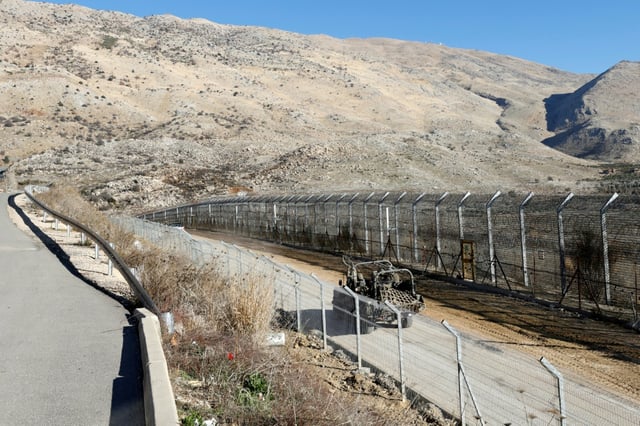 An Israeli army vehicle patrols near the fence leading into the UN-patrolled buffer zone separating Israeli and Syrian forces on the Golan Heights