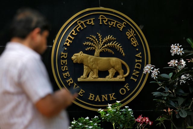 A man checks his phone outside the Reserve Bank of India (RBI) headquarters in Mumbai, India, April 5, 2018. REUTERS/Francis Mascarenhas/ File Photo