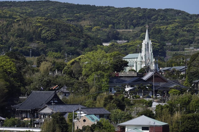 St. Francis Xavier Memorial Church, back right, looks over Zuiunji, lower left, and Komyoji Buddhist temples, in front of the church, in Ikitsuki island in Hirado, southern Japan, Tuesday, April 29, 2025. (AP Photo/Hiro Komae)