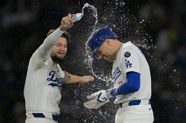 The Dodgers’ Freddie Freeman, right, is doused with water by teammate Andy Pages after hitting a walk-off double in the 10th inning to give them a 6-5 victory over the New York Mets on Tuesday night at Dodger Stadium. The Dodgers tied the score in the bottom of the ninth on Max Muncy’s second homer run of the game. (AP Photo/Jayne Kamin-Oncea)