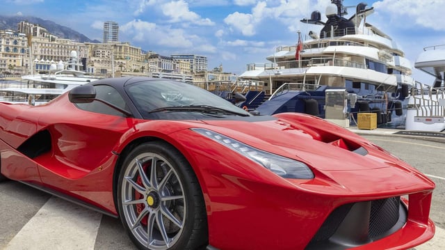 Jachthafen von Monte Carlo mit Luxusyachten und Autos in der Bucht von Monaco.
