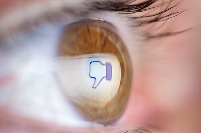 Daumen-runter-Emoji spiegelt sich in einem Auge