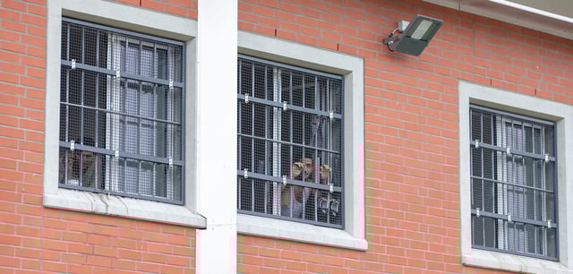 Insassen blicken durch vergitterte Fenster in der Abschiebehaftanstalt für Ausreisepflichtige in Büren (Archivbild)