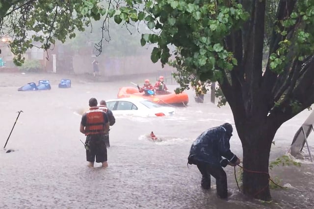Firefighters rush to a submerged vehicle in Wichita, Kan., on June 3, 2025.