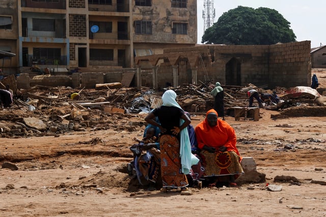 People are seen near their collapsed houses following a flooding that killed 151 people and forced several thousand from their homes in Mokwa, Niger State, Nigeria, May 31, 2025. REUTERS/Stringer/File Photo
