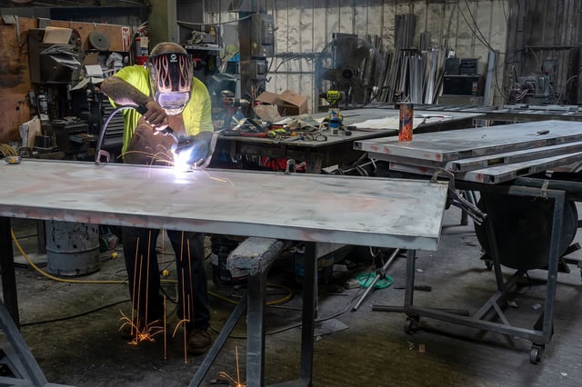 A worker arc welds a metal door during production at the Metal Manufacturing Co. facility in Sacramento, California, on May 27, 2025.