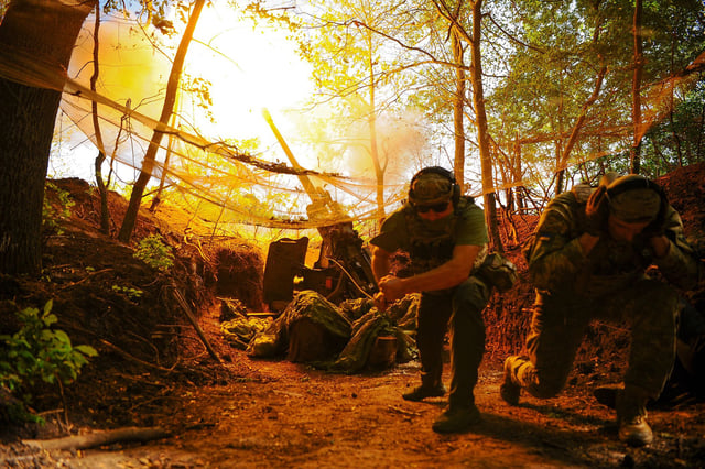 Ukrainian soldiers fire a Howitzer towards Russian troops on a front line in Ukraine's Kharkiv region on Monday.