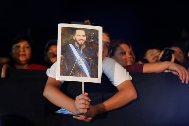 A boy holds an image of El Salvador's President Nayib Bukele, as he waits him to arrive to deliver a speech at an event, to mark the first year of Bukele's second term in office, in San Salvador, El Salvador June 1, 2025. REUTERS/Jose Cabezas