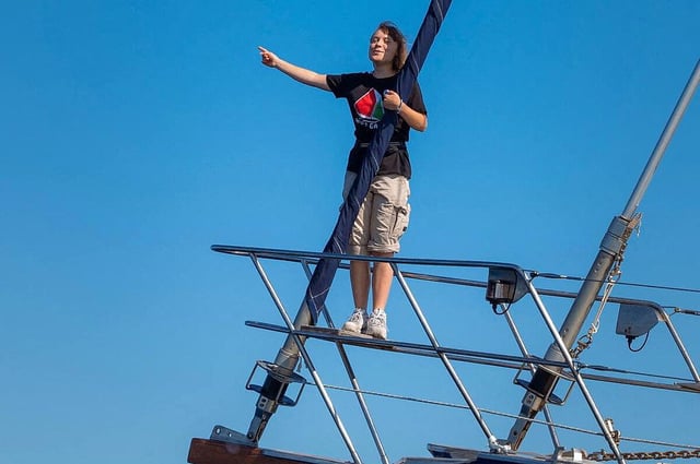 Greta Thunberg steht auf bugseitig auf der Reling des Schiffs