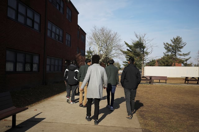 A group of Afghan youth walk outside their temporary housing in Liberty Village on Joint Base McGuire-Dix-Lakehurst in New Jersey, U.S., December 2, 2021.  REUTERS/Barbara Davidson/Pool/File Photo