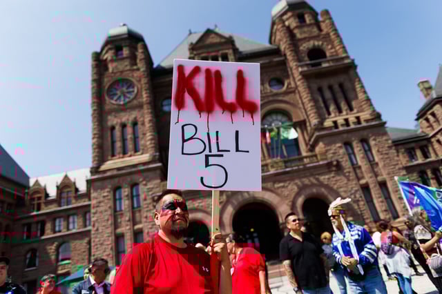 Protesters and community members chant and wave signs as they listen to speakers during a demonstration opposing Bill 5 outside the Ontario Legislature at Queen's Park in Toronto on June 2, 2025.