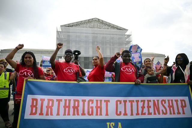 People hold a banner as they participate in a protest outside the US Supreme Court over President Donald Trump's move to end birthright citizenship as the court hears arguments over the order in Washington, DC, on May 15.