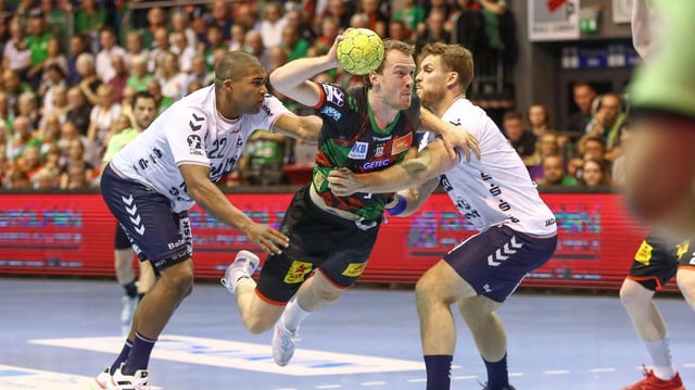 Mads Mensah Larsen und Johannes Golla vom SG Flensburg versuchen Felix Claar vom SC Magdeburg vom Wurf abzuhalten.