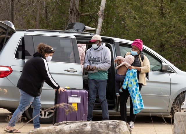 A group of asylum seekers claiming to be from Haiti take their luggage out of a taxi as they arrive near a checkpoint on Roxham Road near Hemmingford, Quebec, Canada April 24, 2022. Picture taken April 24, 2022. REUTERS/Christinne Muschi/File Photo